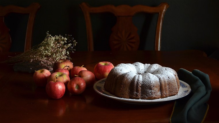 Apple bundt cake on table with apples